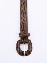 Cinto de cuero sintético con hebilla redonda y estampado animal print.