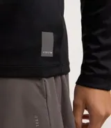 Remera deportiva negra de poliéster con tecnología Dry, cuello redondo, manga larga y estampa lettering en el pecho.