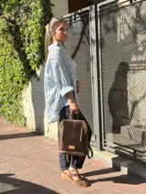 Camisa de corte oversize, con estampado a cuadros en tonos celeste, blanco y beige, cuello camisero, cierre frontal con botones y bolsillo aplicado en el pecho.