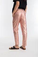 Pantalón de lino metalizado color nude, con cintura alta elástica, corte pitillo, bolsillos laterales y dos bolsillos falsos en la parte trasera.