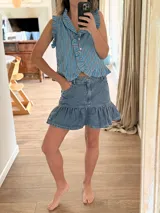 Minifalda de denim con volados en el borde inferior y bolsillos delanteros.