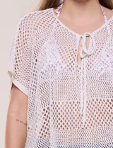 Poncho de tejido calado color beige, con mangas cortas, aberturas laterales y lazos ajustables en el cuello. Modelo Do Everything In Love.