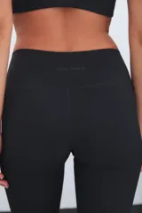 Calza deportiva de tiro alto color marrón, con diseño de perforaciones láser en la parte inferior de las piernas.