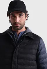 Campera acolchada negra con mangas largas azul marino y capucha gris.