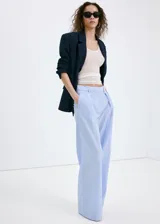 Pantalón de corte recto y tiro bajo, de diseño amplio y fluido, con patrón de rayas verticales finas.