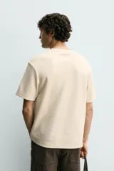 Camiseta relaxed fit color marrón, confeccionada en tejido con estructura, cuello redondo y manga corta.