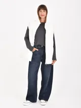 Chaleco puffer gris claro, con cuello alto y cierre frontal.