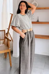 Pantalón palazzo de corte ancho, color azul jean, con pinzas frontales, bolsillos laterales y presillas en la cintura. Incluye un cinturón tejido de rafia con hebilla circular revestida.
