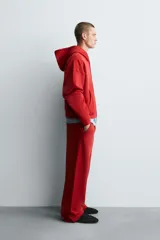Sudadera roja con capucha, cierre frontal con cremallera, bolsillos tipo canguro y corte relaxed boxy fit.