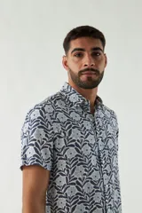 Camisa de hombre de manga corta con estampado floral en tonos azul y blanco, de corte slim fit, con cuello clásico y cierre abotonado. Confeccionada en viscosa.