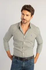 Camisa de manga larga con estampado vichy en tonos verde musgo y blanco. Presenta cuello clásico, cierre frontal con botones y logo bordado en el pecho.