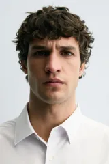 Camisa negra de corte slim fit, con cuello italiano y manga larga con puño abotonado. Cierre frontal de botonadura.