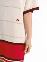 Vestido midi de punto de manga corta con detalles calados y diseño de rayas horizontales tricolor en la parte inferior. Presenta cuello redondo y logo bordado en el pecho.