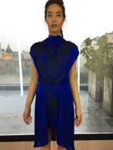 Vestido azul con estampado abstracto en tonos oscuros, corte a la rodilla y cuello alto. Incluye cinturón de la misma tela para ajustar a la cintura.