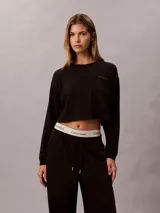 Top cropped de manga larga Calvin Klein, confeccionado en punto de algodón. Presenta cuello redondo, hombros caídos y un bolsillo de parche en el pecho con el logo de la marca bordado.