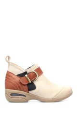 Botín de cuero color beige con detalles en marrón, ajuste con hebilla y suela con cámara de aire.