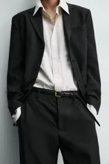 Blazer de corte relajado confeccionado en una mezcla de viscosa y lino. Presenta cuello con solapas de muesca, cierre frontal de tres botones, bolsillo de vivo en el pecho y tres bolsillos con solapa en la cadera. Incluye aberturas en la espalda y medio forro interior.