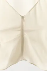 Camisa de viscosa con cuello subido y diseño de manga tipo capa con aberturas laterales. Presenta un corte fluido y cierre posterior con cremallera oculta.