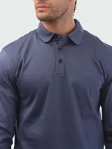 Remera polo de manga larga Boss en color azul marino, confeccionada en algodón interlock. Presenta cierre frontal de dos botones, cuello camisero clásico y sutil logotipo bordado en el pecho.
