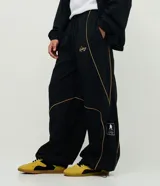 Pantalón deportivo de microfibra color negro, con corte holgado y diseño de piping contrastante en color amarillo. Cuenta con cintura elástica con cordón de ajuste, bolsillos laterales y logo bordado.