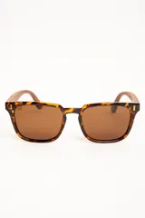 Lentes de sol polarizados con armazón carey y patillas de madera, con cristales marrones de forma cuadrada.