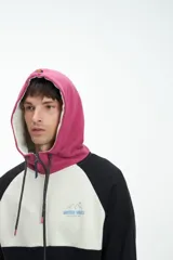 Canguro marrón y blanco con cierre frontal, capucha con cordones y logo bordado en el pecho.