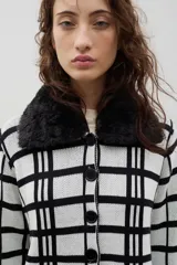 Saco de punto con diseño de cuadros, cierre frontal con botones y cuello de pelo sintético desmontable.