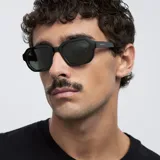 Lentes de sol con montura poligonal color verde oliva y lentes verdes polarizadas.