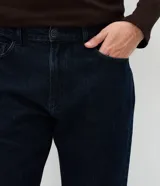 Pantalón de jean corte recto con lavado oscuro uniforme, confeccionado en algodón con elastano. Presenta cintura con presillas, cierre frontal con botón y cremallera, y bolsillos funcionales delanteros y traseros.