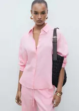 Camisa rosa de lino, de corte oversize, manga larga con puños abotonados y cuello camisero.