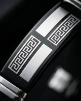 Pulsera de diseño masculino fabricada en acero inoxidable y goma negra, con detalles metálicos decorados con un patrón de guarda griega.