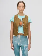 Chaleco de denim liviano con cierre frontal de botones metálicos, detalle de apliques metálicos verticales y ruedo con terminación desflecada.