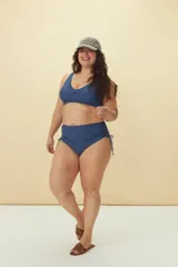 Bombacha de bikini de tiro alto con laterales fruncidos y tiras ajustables, confeccionada en tela lisa de color azul.