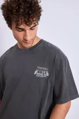 Remera de algodón color marrón con efecto lavado, corte oversize y estampa pequeña en el pecho.