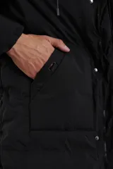 Campera negra con capucha, cierre frontal con cremallera y bolsillos laterales con botón a presión.