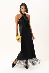 Vestido midi de satén color negro, con escote halter cruzado y ruedo terminado en flecos largos.