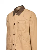 Chaqueta color taupe con cuello de pana marrón, cierre frontal de botones, un bolsillo con cierre en el pecho y dos bolsillos de parche con solapa en la parte inferior.