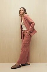 Pantalón de tiro alto color ladrillo, de corte ancho y con cinturón de la misma tela.