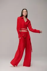 Camisa de chiffon color rojo, con diseño cruzado, mangas largas abullonadas y detalle de lazo para anudar en la cintura. Presenta cuello camisero y corte cropped.