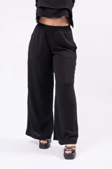 Pantalón palazzo negro de corte wide leg, con cintura elastizada de tiro medio-alto y confeccionado en tejido liviano con caída.