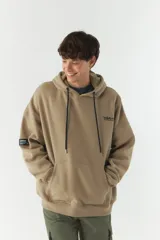 Canguro de felpa color beige con capucha, cordones negros, bolsillo tipo canguro y puños y cintura acanalados. Estampado con el logo de la marca en el pecho y parche con el logo en la manga izquierda.