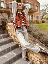 Chaleco color ladrillo con textura, ribeteado en blanco y negro.