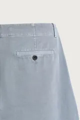 Pantalón chino para hombre de corte relajado, confeccionado en tejido de algodón con efecto lavado en color celeste. Cuenta con bolsillos delanteros, bolsillos traseros de vivo con botón y cierre frontal con cremallera y botón.