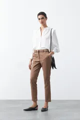 Pantalón de vestir negro de corte recto, con cintura estructurada y costura central vertical en las piernas que aporta un acabado sastrero.