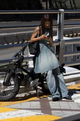 Vestido corto de denim con cuello redondo y manga sisa. Presenta costuras inclinadas y un bajo asimétrico. Cierre con cremallera en la espalda.