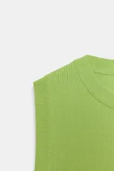 Top crop de tejido de punto color beige claro, con cuello redondo y manga sisa. Presenta acabados en rib en el cuello, sisas y bajo.