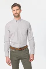 Camisa de manga larga a cuadros pequeños en tonos celeste y blanco, con bolsillo en el pecho y cuello abotonado. Corte slim fit hasta talle XL, a partir de XL classic fit.