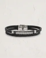 Pulsera doble de color negro, compuesta por una banda de cuerina trenzada y una placa metálica central con diseño de guarda griega grabada.