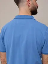 Remera polo negra de piqué de algodón con cuello clásico y tapeta de dos botones. Presenta un pequeño logo bordado en el pecho.