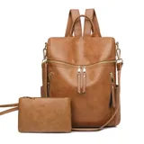 Mochila de eco cuero color suela, de diseño amplio con múltiples bolsillos externos con cierre y tiradores largos. Cuenta con asa superior y correas ajustables.